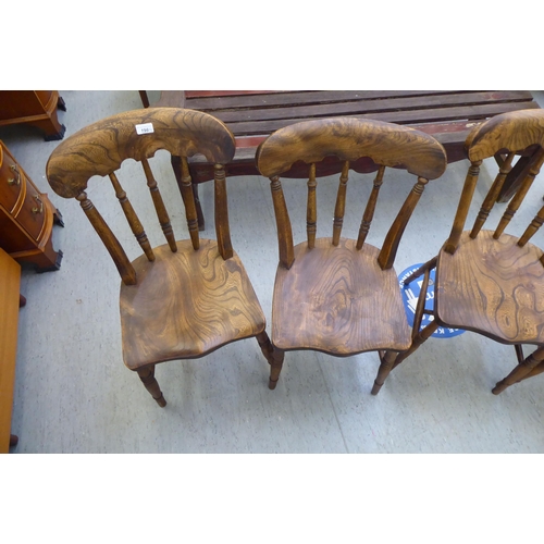 198 - A set of four early 20thC beech and elm framed Windsor kitchen chairs, the solid seats raised on tur... 