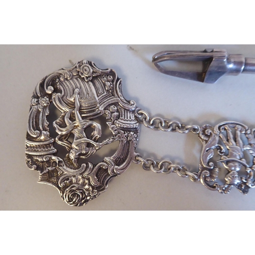 23 - White coloured metal items: to include an ornately cast tablet and chain link belt