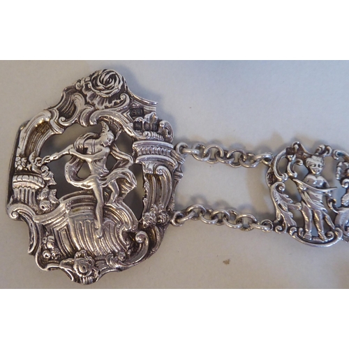 23 - White coloured metal items: to include an ornately cast tablet and chain link belt