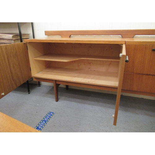 245 - A modern Uniflex Gunther Hoffstead  teak sideboard with a low railed back, the top incorporating an ... 