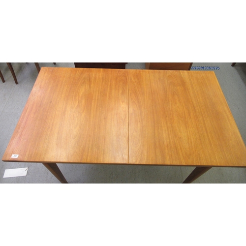 260 - A 1970s teak dining table with an integral additional leaf, raised on tapered legs  29