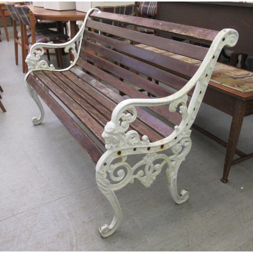 264 - A Victorian style white painted iron garden seat with stained wooden slats  48