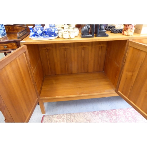 269 - A 1970's teak sideboard with four panelled doors, raised on square legs  38