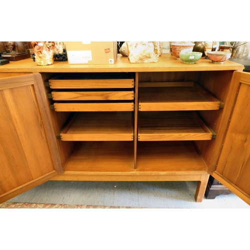 269 - A 1970's teak sideboard with four panelled doors, raised on square legs  38