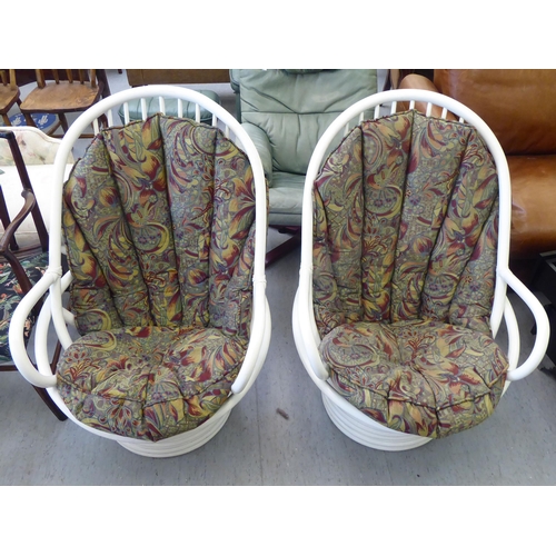 271 - A pair of white painted cane spindled conservatory tub chairs with a floral patterned fabric cushion... 