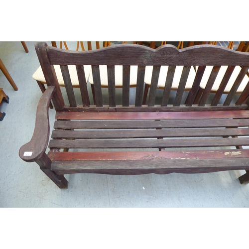 275 - A modern teak framed garden seat of slatted construction with level arms  60