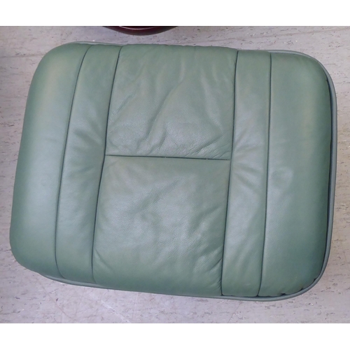 276 - A modern cushioned pale green soft hide upholstered, adjustable lounge chair with enclosed arms, rot... 