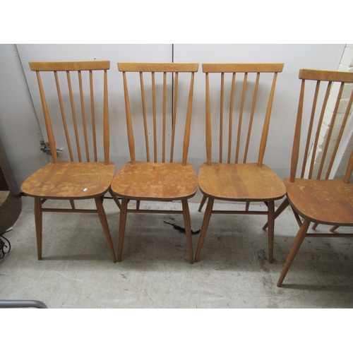 280 - A set of seven Ercol beech and elm framed spindle back dining chairs, the solid seats raised on turn... 