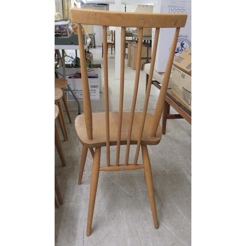 280 - A set of seven Ercol beech and elm framed spindle back dining chairs, the solid seats raised on turn... 