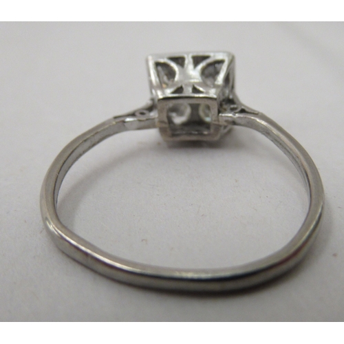 309 - A white metal ring, set with four diamonds, in a square mount