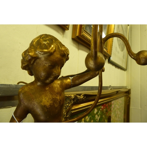 50 - A late 19thC gilded softwood applique, fashioned as a cherubic figure, holding a three branch picket... 