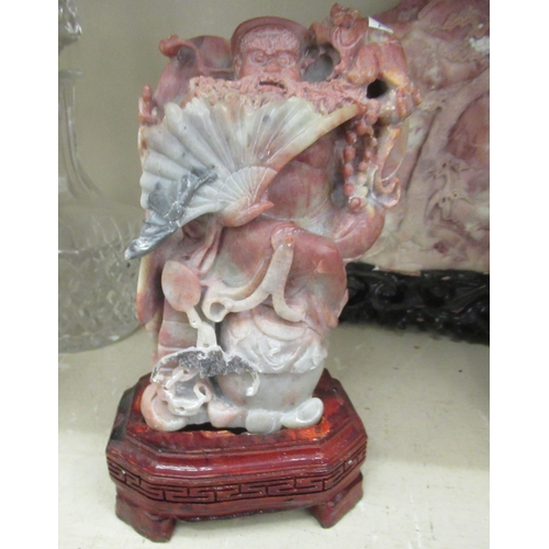 70 - Three 20thC Chinese carved soapstone sculptures: to include a figure holding a fan  10