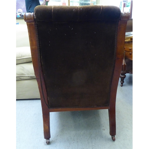 73 - A late Victorian carved mahogany showwood framed library chair with a high scrolled back and level e... 