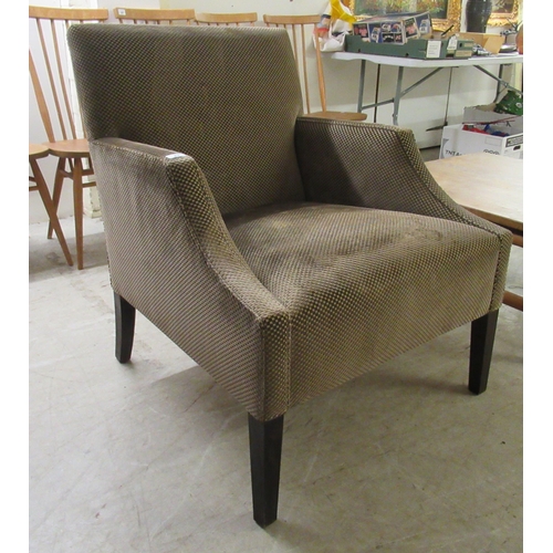 83 - A modern patterned fabric covered enclosed armchair, raised on square, tapered legs