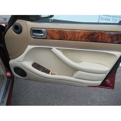 150 - A 1995 Jaguar Sovereign automatic 3.2ltr petrol, five door saloon in red livery with cream coloured ... 