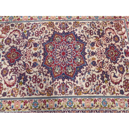 162 - A Persian rug with floral motifs, on a cream coloured and red ground  80