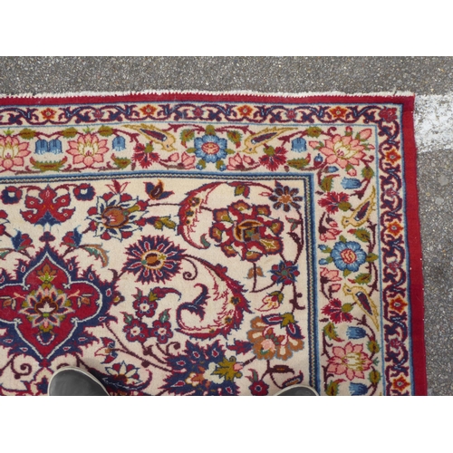 162 - A Persian rug with floral motifs, on a cream coloured and red ground  80