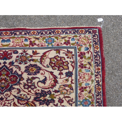 162 - A Persian rug with floral motifs, on a cream coloured and red ground  80