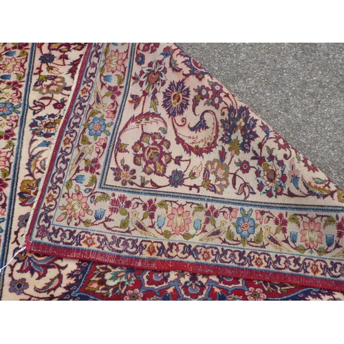 162 - A Persian rug with floral motifs, on a cream coloured and red ground  80