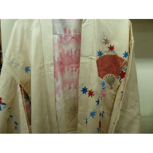 30 - A Japanese kimono, lined and printed in colours with a flowerhead design, on a black ground; and lad... 