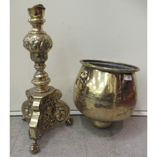 65 - An early 20thC cast brass jardinière with opposing mask ring handles, on a floral decorated c... 