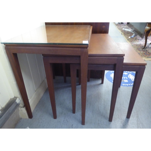107 - A nesting set of three modern teak occasional table, raised on square, tapered legs largest 20