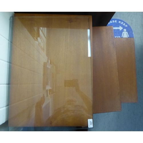 107 - A nesting set of three modern teak occasional table, raised on square, tapered legs largest 20
