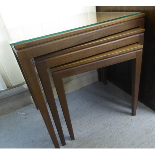 107 - A nesting set of three modern teak occasional table, raised on square, tapered legs largest 20