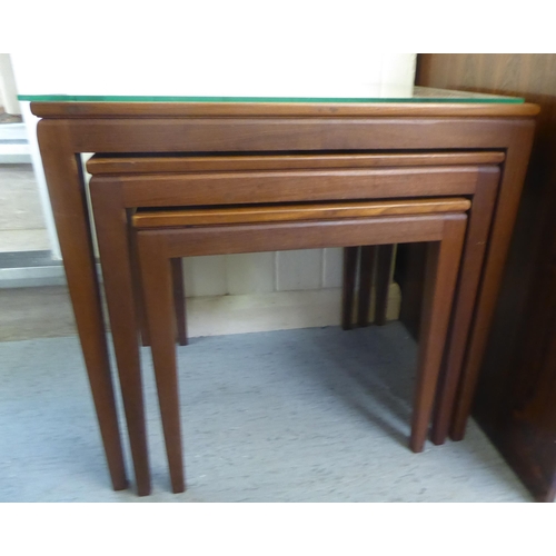107 - A nesting set of three modern teak occasional table, raised on square, tapered legs largest 20