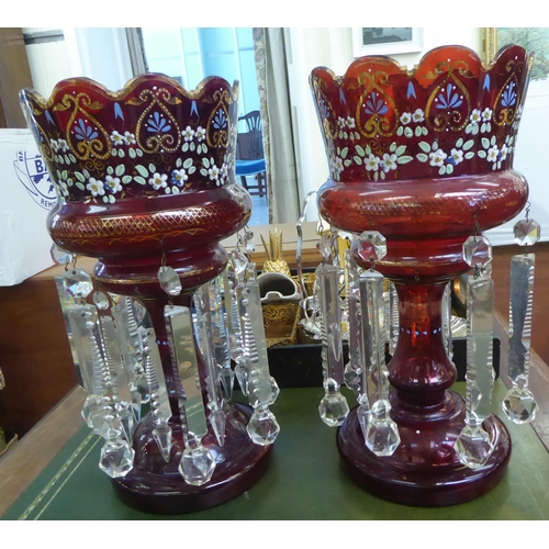 112 - A pair of late Victorian overpainted cranberry coloured glass lustre vases with clear crystal pendan... 