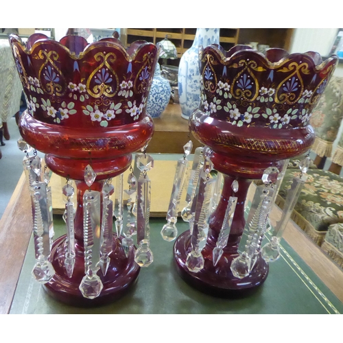 112 - A pair of late Victorian overpainted cranberry coloured glass lustre vases with clear crystal pendan... 