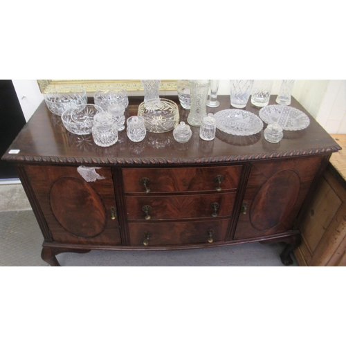145 - A 1930s mahogany bow front sideboard with a central bank of three drawers, flanked by a pair of pane... 