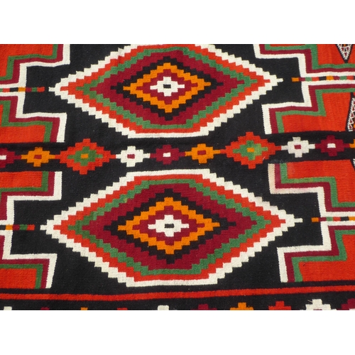 16 - A Kelim rug with geometric motifs, on a multi-coloured ground  52