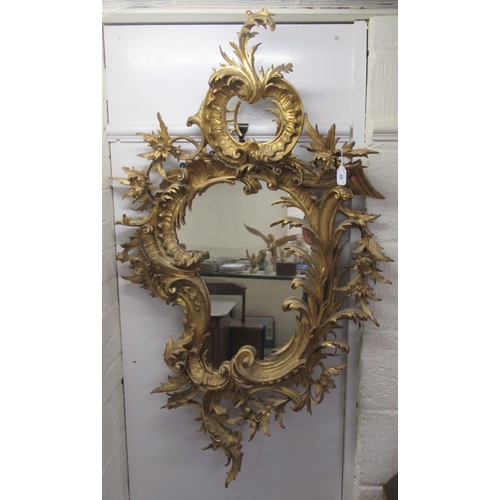 190 - A late 18th/early 19thC mirror, set in a carved giltwood, foliate scrolled and floral, rococo style ... 
