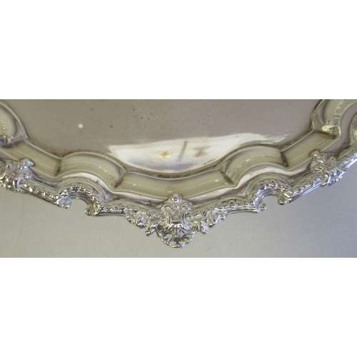 193 - A Georgian style silver waiter with a raised and decoratively cast piecrust border, elevated on scro... 