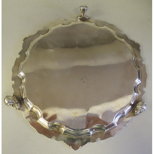 193 - A Georgian style silver waiter with a raised and decoratively cast piecrust border, elevated on scro... 