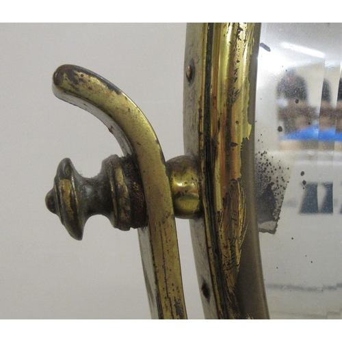 194 - An early 20thC brass framed dressing room toilet mirror, the bevelled plate pivoting/rotating on a t... 