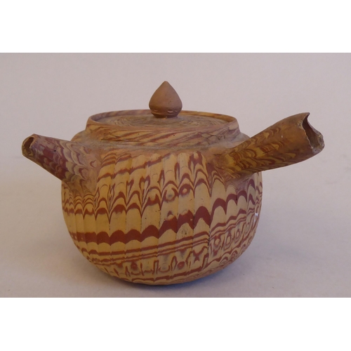 199 - An antique Japanese agate ware Saki pot of bulbous form with a short spout, side handle and cover