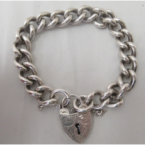 202 - A silver curb link bracelet, on a padlock clasp and safety chain&nbsp; mixed marks&nbsp;