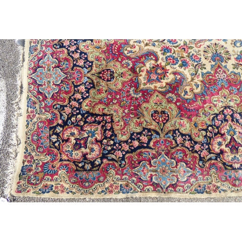 212 - A Persian design rug with dense floral motifs on a beige ground   124
