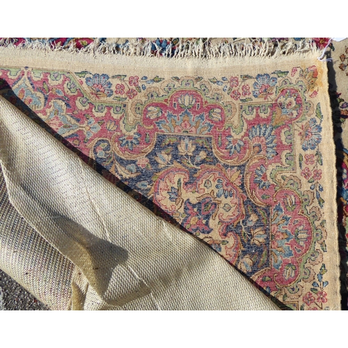 212 - A Persian design rug with dense floral motifs on a beige ground   124