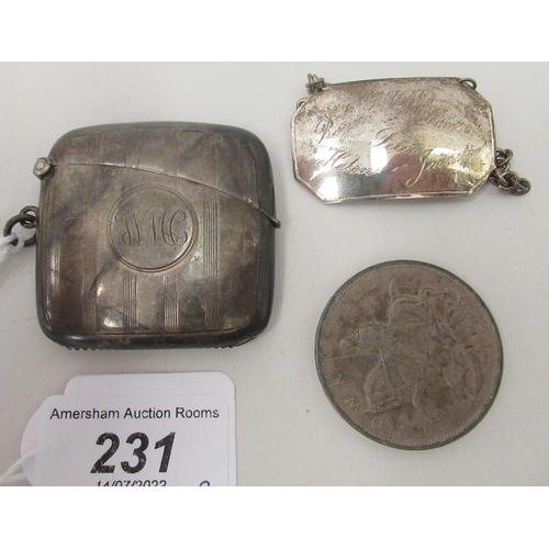 231 - A silver vesta case with a strike plate, a pendant ring and hinged lid; and a silver wine label&nbsp... 