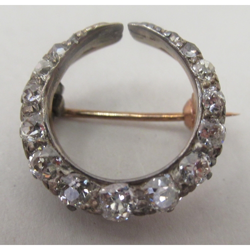 232 - A gold coloured metal crescent brooch, claw set with graduated diamonds