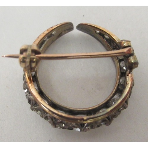 232 - A gold coloured metal crescent brooch, claw set with graduated diamonds