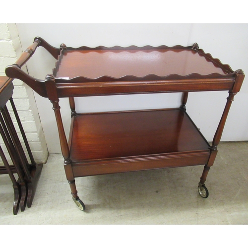 349 - A Victorian style mahogany two tier serving trolley, the uppermost with a wavy edged gallery, on sle... 