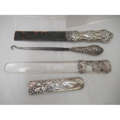 77 - Three early 20thC Art Nouveau silver page turner handles; and a contemporary silver handled button h... 