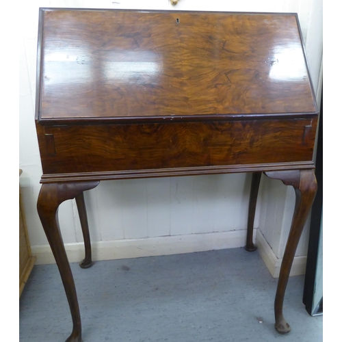 82 - A 1930s walnut finished clerks bureau. the fall flap enclosing a part fitted interior, raised on sle... 