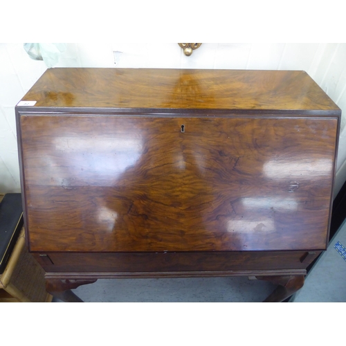82 - A 1930s walnut finished clerks bureau. the fall flap enclosing a part fitted interior, raised on sle... 