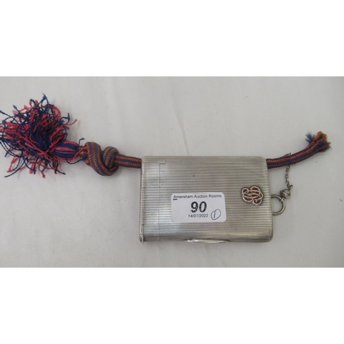 90 - An early 20thC G Keller French silver coloured metal cigarette case with a ribbed body and hinged li... 