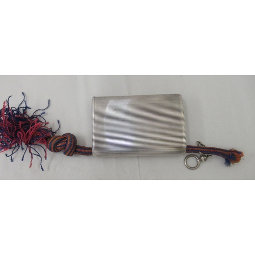 90 - An early 20thC G Keller French silver coloured metal cigarette case with a ribbed body and hinged li... 